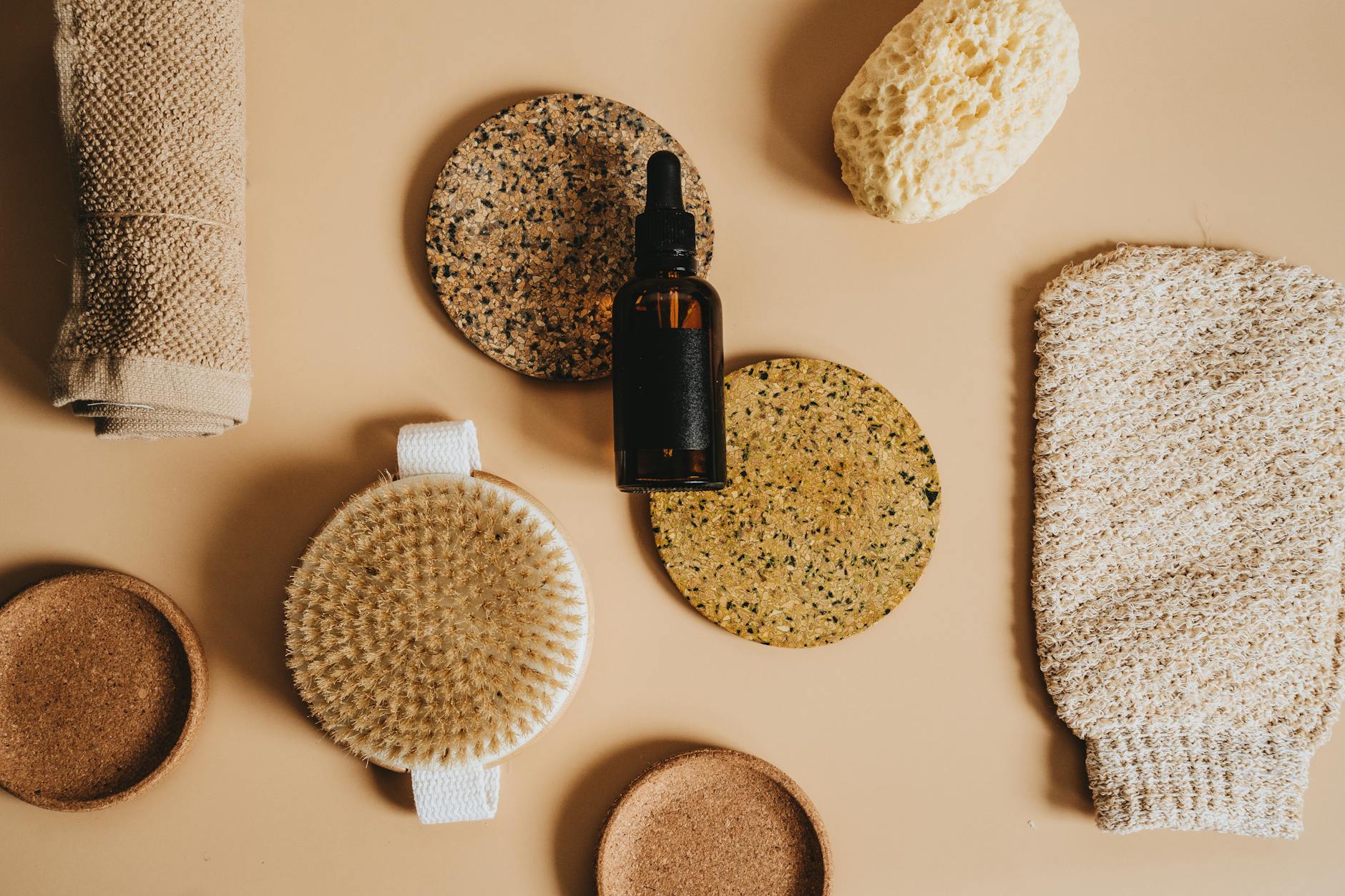 Ekologiczne akcesoria kąpielowe ułożone na beżowym tle