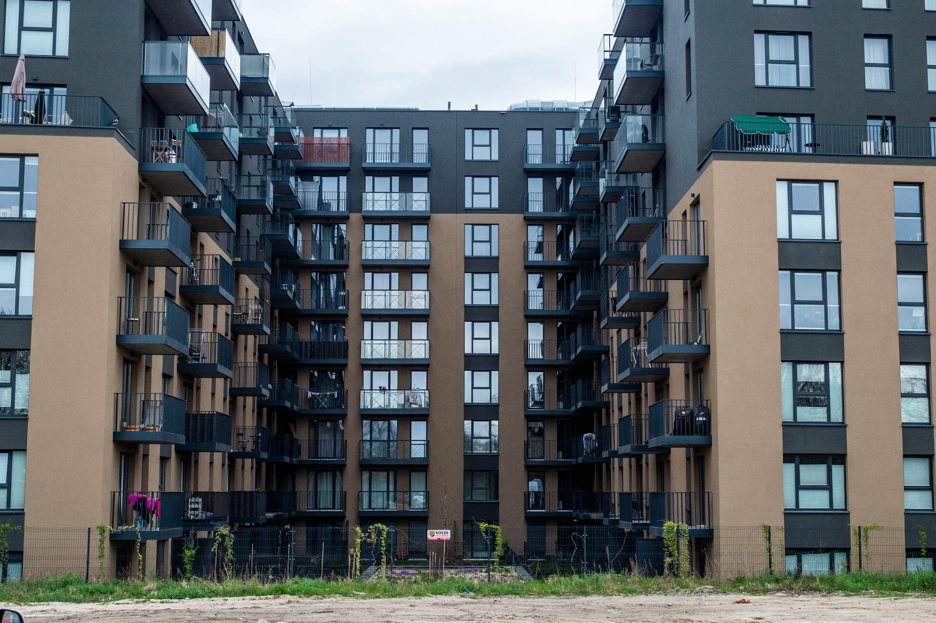 Nowoczesna fasada apartamentowca z balkonami w gęstej zabudowie miejskiej