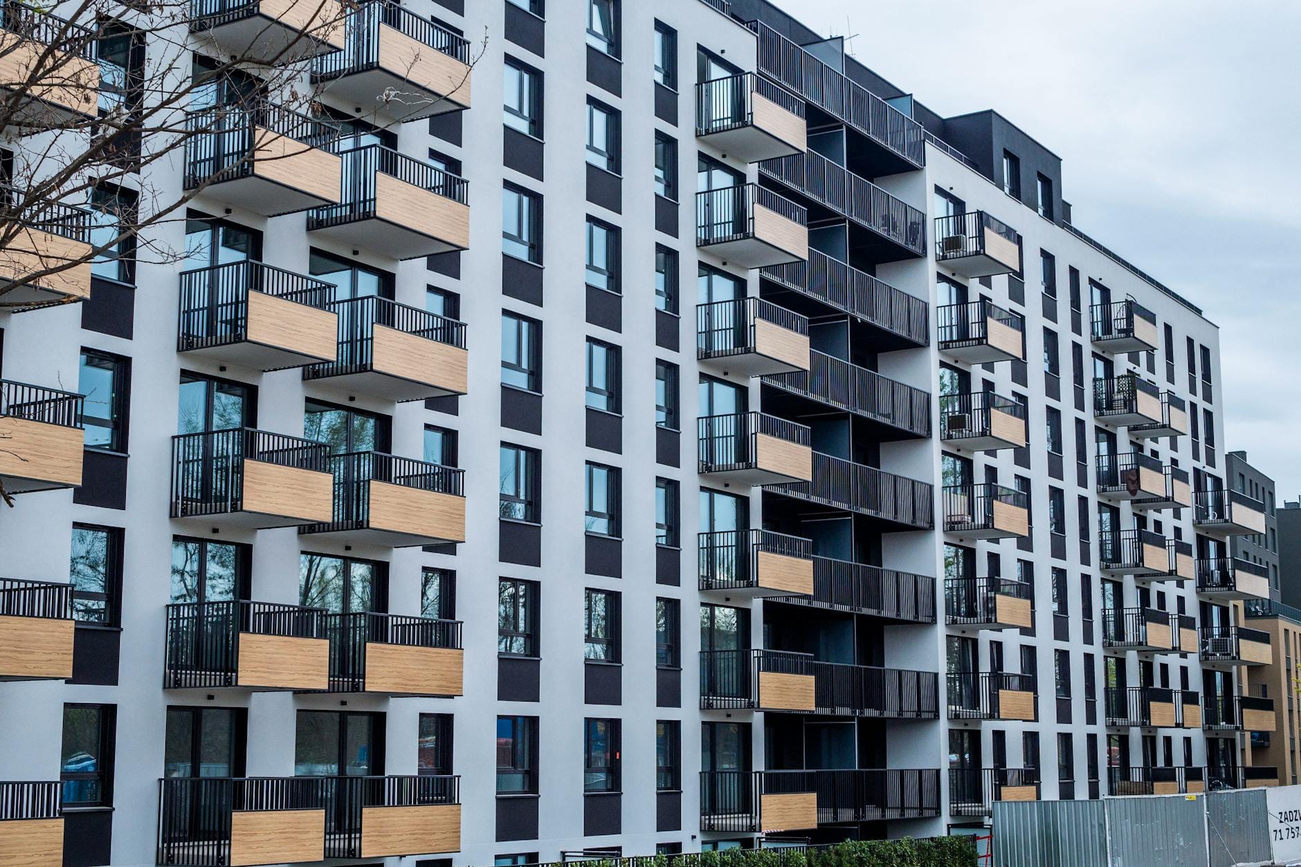 Nowoczesny blok mieszkalny z balkonami w gęstej zabudowie miejskiej